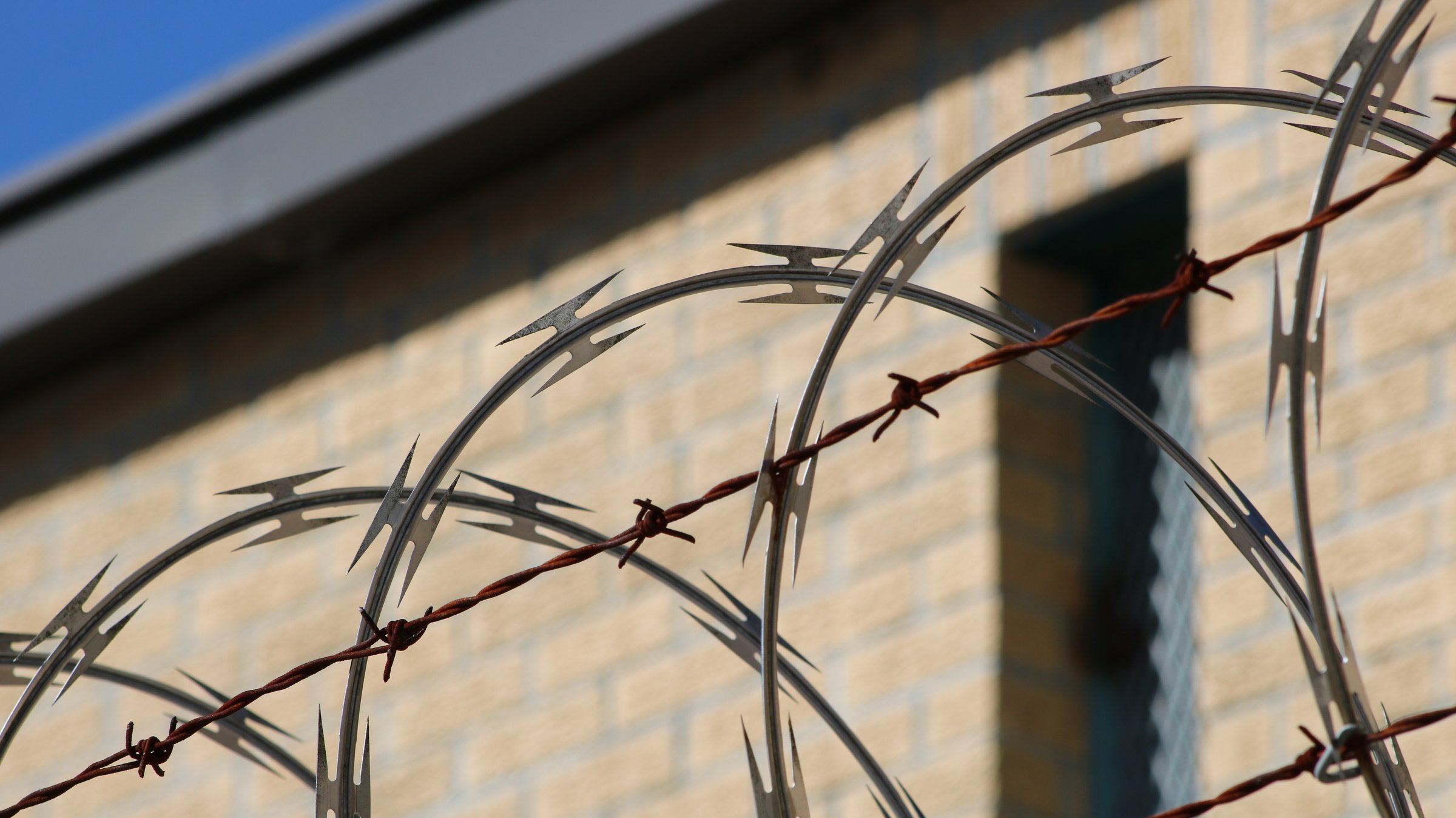 Black Metal Wire Fence Near Brown Concrete Building